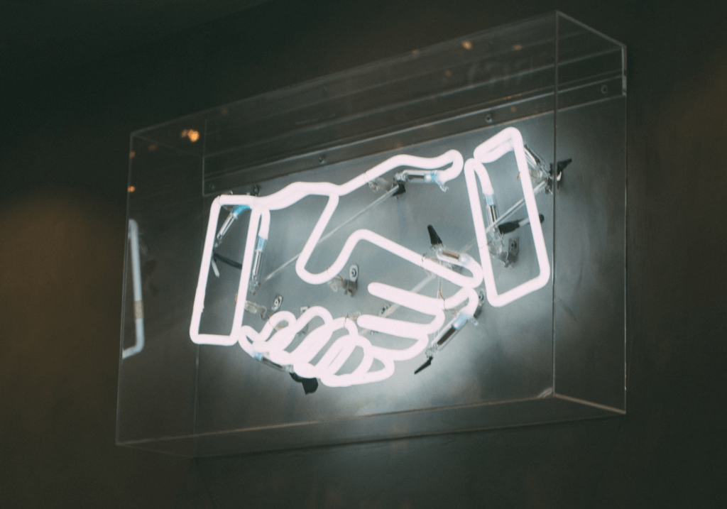Neon Sign in the shape of a hand shake.